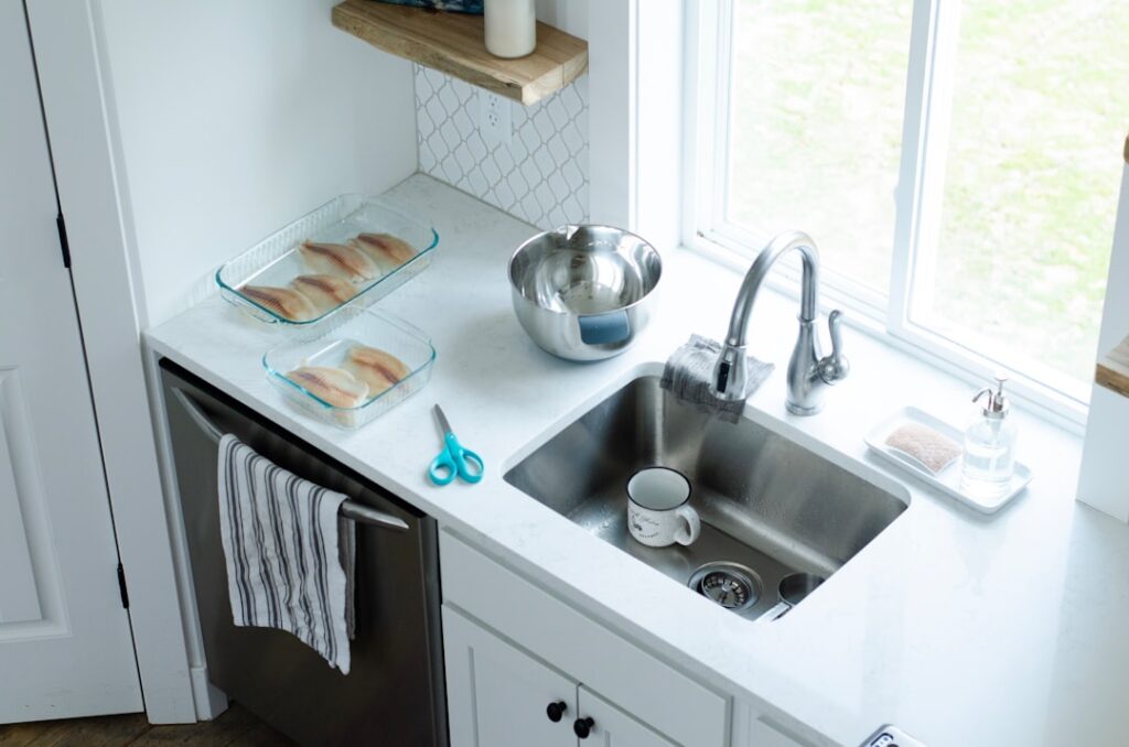 Espacio organizado debajo del fregadero de la cocina con almacenamiento práctico